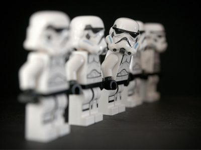 Line of stormtroopers with one stormtrooper leaning forward and looking down the line. Describes being different to everyone else.